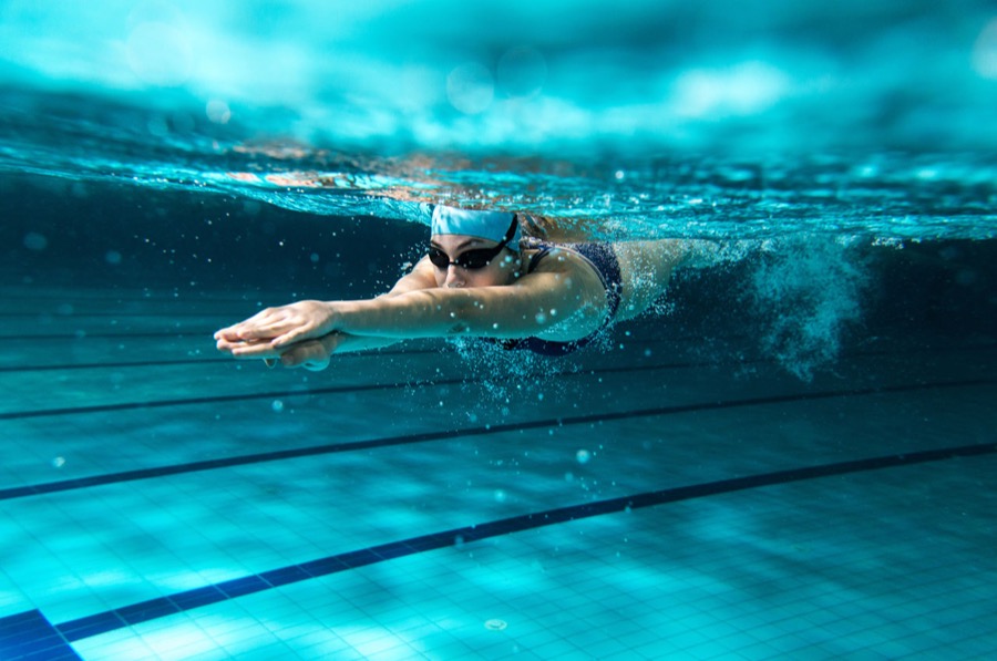 Nuotatrice a stile libero vista sott'acqua nella corsia della piscina
